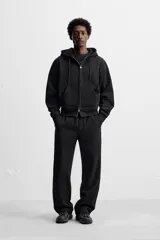 Pantalón jogger gris de corte recto, confeccionado en tejido de algodón compacto con interior en rizo. Cuenta con cintura elástica ajustable con cordón interior, bolsillos frontales y bolsillo de doble vivo en la espalda.