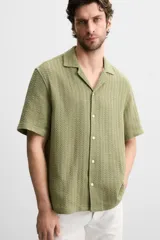 Camisa verde oliva de manga corta con cuello bowling, corte relaxed fit y cierre frontal con botones.