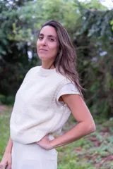 Chaleco de punto color crema con cuello redondo y sisas amplias.