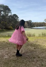 Vestido corto rosa de fibrana, corte oversize, con cuello camisero, mangas cortas y bolsillos laterales.