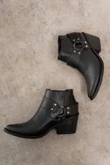 Bota corta de cuero negro con puntera fina, taco cuadrado y correa con hebilla metálica.
