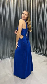Vestido largo de fiesta color azul eléctrico con lurex, de un solo hombro, con abertura lateral en la falda y corte en la cintura.