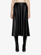 Falda maxi negra de corte acampanado, con cintura elástica y acabado brillante, posiblemente efecto cuero o vinilo.