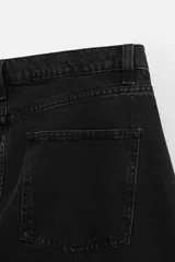 Pantalón de jean negro de corte amplio, estilo balloon fit, con cinco bolsillos, efecto lavado y cierre frontal con botones.