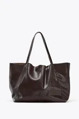 Bolso maxi shopper de cuero color marrón oscuro, con pespuntes a tono y asas de hombro. Incluye cierre con tiras y botón, y cartera con bolsillo extraíble.