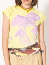 Musculosa amarilla con estampado de hongos en tonos lila y detalle de paisaje en la parte inferior.