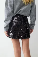 Minifalda negra de punto con lentejuelas plateadas, de calce ajustado y confección en tejido de punto tipo twill.