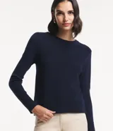 Blusa de punto rosa con textura acanalada, cuello redondo y mangas largas.