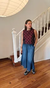 Remera corta de tafeta color verde militar con lunares de terciopelo negros, corte a la base y botón en la parte trasera.