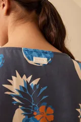 Vestido corto azul con estampado de ananás y mangas cortas con dobladillo.