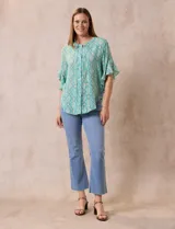 Blusa de gasa estampada con cuello a la base, abertura central con botones y mangas cortas con volados.
