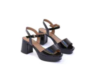 Sandalias de charol negro con plataforma y tacón cuadrado. Tira delantera ancha y tira al tobillo con hebilla dorada.