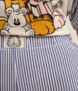 Conjunto de pijama corto de viscosa con remera de mangas cortas rayadas y estampado de Garfield, y short estilo bóxer a rayas con cintura elástica.