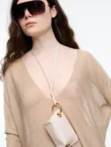 Sweater de calce amplio con escote en V, hecho en hilado ligero con textura seca y look natural. Tiene puños altos y cambio de punto en el centro del delantero, que aporta un detalle visual distintivo. Ideal para media estación, su diseño cómodo y relajado se adapta fácilmente a looks casuales y descontracturados.