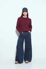 Jean ancho de tiro medio, color azul oscuro, con corte wide leg y paneles de costura visibles en las piernas.