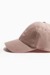Gorra de béisbol color rosa con bordado frontal de la frase "Palm Springs California" en color blanco.