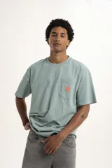 Remera color celeste con bolsillo en el pecho y logo estampado en color naranja.