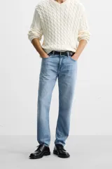 Pantalón de jean celeste de corte slim fit y tapered, con cinco bolsillos, efecto lavado y cierre frontal con cremallera y botón.