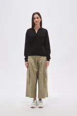 Buzo negro de manga larga con cuello polo y escote en V. Tiene un corte holgado y puños y dobladillo acanalados.