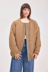 Campera acolchada reversible color verde militar, con capucha y cierre frontal con botones a presión.