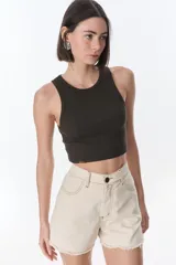 Short de jean color crudo, de tiro alto, con bolsillos delanteros y traseros, y ruedo desflecado.