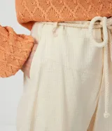 Pantalón zanahoria color crema con textura de cuadros, cordón ajustable en la cintura, bolsillos delanteros y traseros.