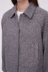 Chaqueta de lana color gris medio, de corte holgado, con solapa y mangas largas.
