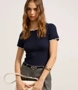 Blusa blanca de algodón con cuello redondo y mangas cortas con detalle ondulado en negro.