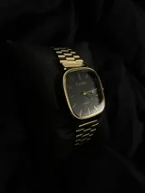 Reloj Casio Quartz dorado con esfera negra y pulsera de eslabones.