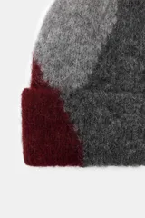 Gorro beanie de lana multicolor con diseño de bloques de color en gris, azul y azul marino.