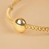 Pulsera de oro amarillo y blanco 18k con esferas y malla extensible.