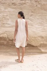 Vestido corto color beige, sin mangas y con cuello redondo.
