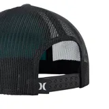 Gorro estilo trucker de color gris oscuro, con paneles traseros de malla negra. Presenta un parche frontal rectangular con un diseño de olas en tonos turquesa, blanco y gris, y el logo "HURLEY" en la parte inferior. Tiene visera plana y cordón decorativo en la unión de la visera y el cuerpo.