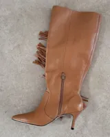 Bota alta de cuero color borgoña con taco fino y detalle de flecos en el lateral.