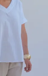 Remera blanca de corte holgado con cuello en V y mangas cortas con dobladillo.