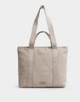 Bolso tipo shopper color beige, con diseño acolchado y pespuntes ondulados. Tiene doble asa de hombro y correa extraíble regulable.