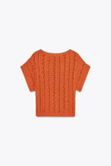 Top corto de punto color naranja, con cuello redondo amplio y manga corta.
