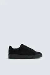 Zapatilla de hombre color negro, de estilo casual, con cordones y parte superior de piel con acabado serraje. Suela ligera a tono.