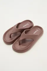 Ojotas marrones con textura en la plantilla y logo de la marca en el lateral.