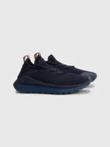 Zapatillas de running Tommy Hilfiger color azul marino, confeccionadas en tejido de punto elástico de poliéster reciclado. Cuentan con plantilla de acupresión, suela dentada de goma y caucho, trabilla distintiva y monograma TH grabado en la entresuela.