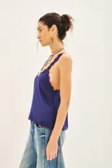 Top bretelero azul oscuro con escote en V, ribetes de puntilla a tono en escote, breteles y sisas. Presenta tachas termo adhesivas distribuidas en el frente.