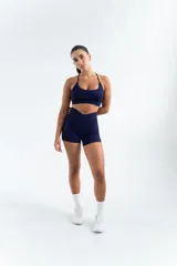 Conjunto deportivo azul marino compuesto por un top con tirantes finos y un short de cintura alta con diseño cruzado.