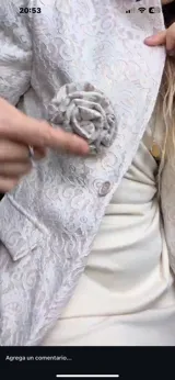 Chaqueta color crema de encaje con solapas y botón frontal. Incluye un prendedor de flor removible.