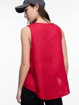 Top sin mangas color beige, confeccionado en lino, con escote en V y calce amplio. Presenta laterales en color blanco.