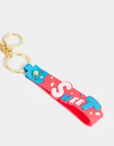 Llavero con forma de cámara de fotos azul y roja con strap de silicona con la palabra "Sweet" en letras blancas. Proyecta imágenes (luz y sonido).