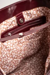 Bolso tipo tote grande color bordó, de cuero vegano, con doble asa corta.