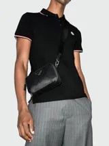 Polo de piqué de algodón blanco de manga corta, con cuello y puños con ribetes tricolor (rojo, blanco y azul marino). Presenta un pequeño logo bordado en el pecho.