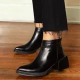 Botines negros de cuero vacuno con detalle de cuero con textura de cocodrilo en el talón y cierre dorado. Taco cuadrado de madera con folia de cuero de 5cm y entre suela de goma de 1,5cm.