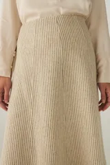Falda midi evasé color beige, tejida en lana fina con detalle de pespuntes y cierre oculto.