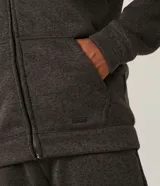 Campera de algodón gris oscuro jaspeado, con cierre frontal de cremallera, capucha con cordones trenzados y bolsillo canguro.